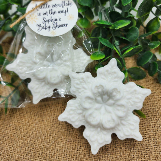 White snowflake-shaped favors with a tag on a burlap background