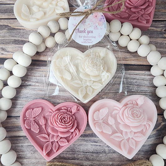 Heart-shaped floral favors on a wooden surface with white beads