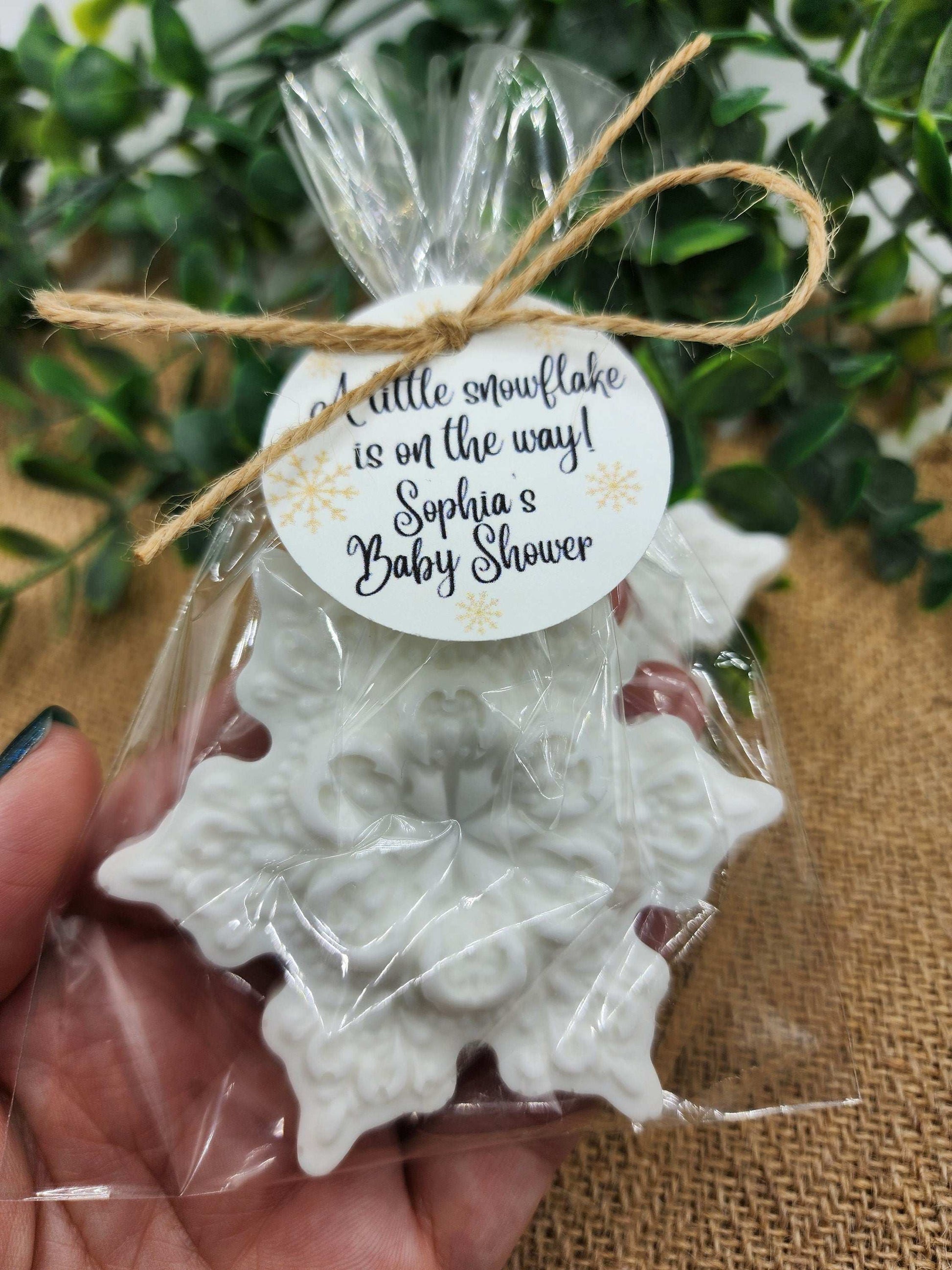 White snowflake-shaped favor with a tag on a burlap surface