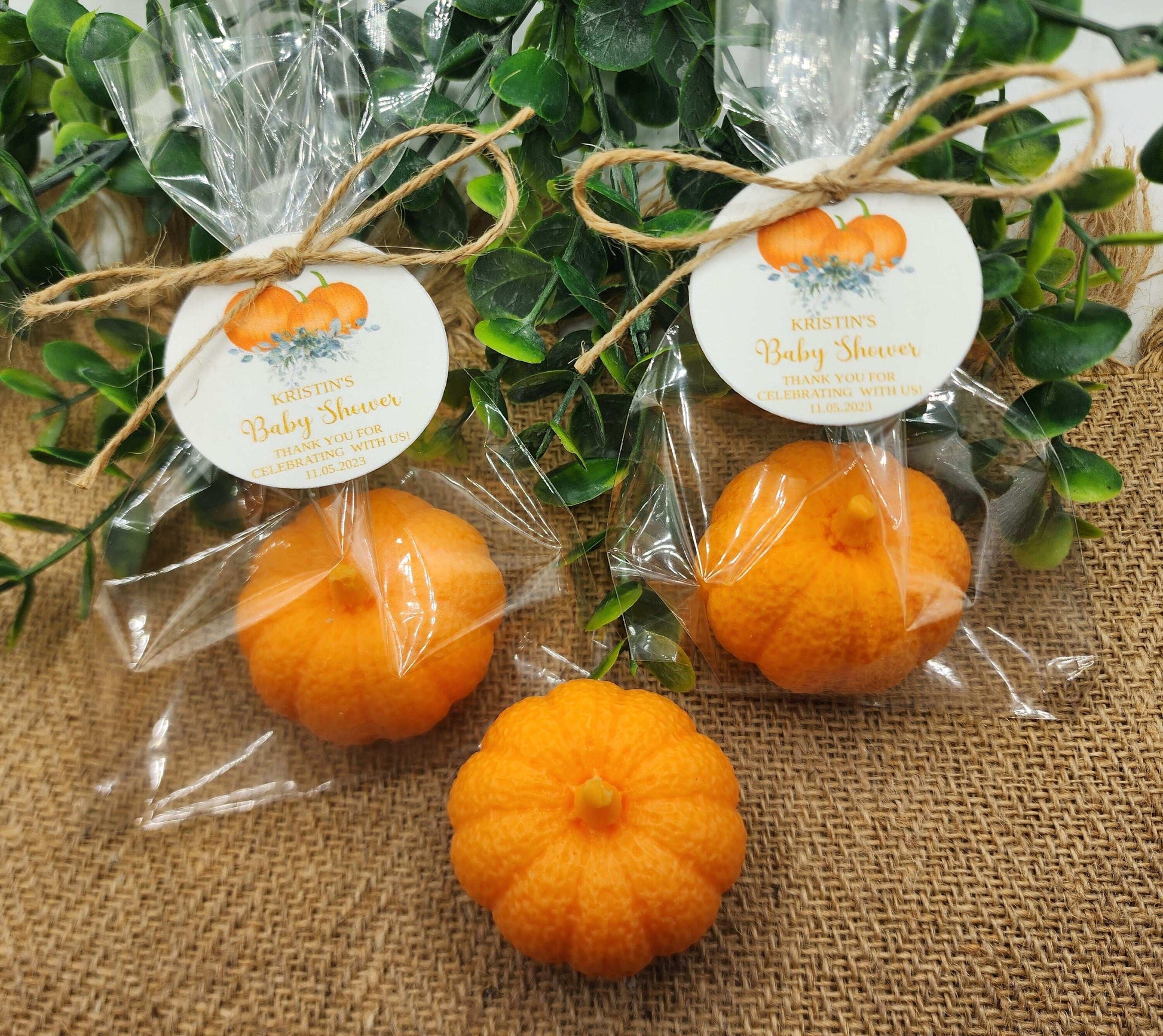 Orange pumpkins in clear packaging with labels on a textured surface